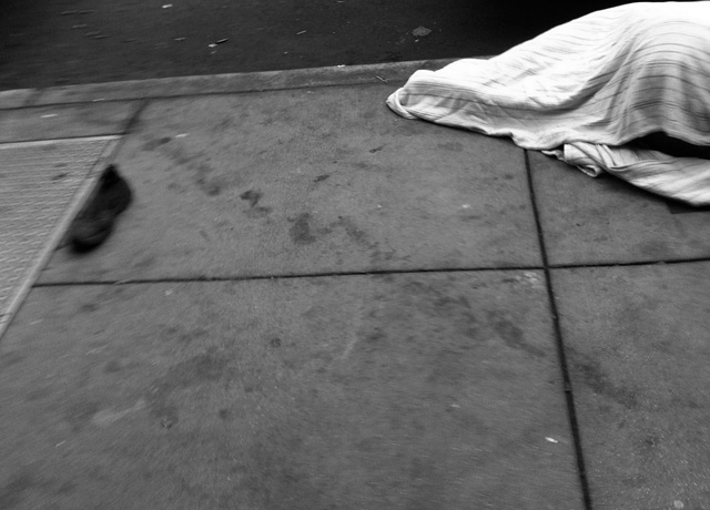 homeless person under blanket